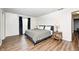 Well lit bedroom featuring wood floors, queen bed, and dark curtains at 6005 Apache Dr, Indianapolis, IN 46254