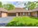 Charming brick home with a well-manicured lawn and attached two-car garage at 6005 Apache Dr, Indianapolis, IN 46254