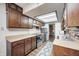 Functional kitchen with wooden cabinets, updated appliances, and a bright skylight at 6005 Apache Dr, Indianapolis, IN 46254