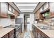 Long kitchen featuring stainless steel appliances, and laminate flooring at 6005 Apache Dr, Indianapolis, IN 46254