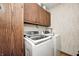 Laundry area with modern washer and dryer, upper cabinets and decorative wallpaper at 6005 Apache Dr, Indianapolis, IN 46254