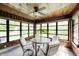 Sunroom featuring bright windows, wood paneling and ceiling fan at 6005 Apache Dr, Indianapolis, IN 46254
