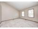 An empty bedroom with neutral walls, two windows, and carpet flooring at 6354 Cotton Bay N Dr, Indianapolis, IN 46254