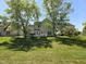 Expansive backyard with a well-manicured lawn, mature trees, and a charming deck creating a serene outdoor space at 6369 Kelsey Dr, Indianapolis, IN 46268