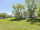 Lush backyard showcasing mature trees, a well-kept lawn, with a white exterior and cozy deck for relaxing at 6369 Kelsey Dr, Indianapolis, IN 46268