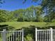 Green backyard with many trees, framed by a white railing at 6369 Kelsey Dr, Indianapolis, IN 46268