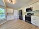 Modern kitchen with white cabinets, black stainless appliances, and modern flooring at 6369 Kelsey Dr, Indianapolis, IN 46268