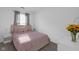 Bright bedroom with a comfortable bed, soft pink bedding, and two white nightstands with lamps at 6707 Greendale Ln, Indianapolis, IN 46241
