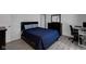 Comfortable bedroom featuring a bed with blue comforter, dresser with mirror, and neutral-toned flooring at 6707 Greendale Ln, Indianapolis, IN 46241