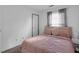 Bedroom featuring a bed with decorative pillows, a window with blinds, and a neutral color scheme at 6707 Greendale Ln, Indianapolis, IN 46241