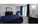 Modern bedroom with a bed, dresser, desk, and a view out of a window with natural light and dark curtains at 6707 Greendale Ln, Indianapolis, IN 46241