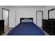 Bright bedroom showcasing a bed with blue comforter, a dresser with a mirror, and neutral flooring at 6707 Greendale Ln, Indianapolis, IN 46241