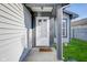 View of front porch that leads to a welcoming door with a wind chime and a 
