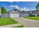 Exterior view of home showing a gray fence, attached garage, concrete driveway, and lush green lawn at 6707 Greendale Ln, Indianapolis, IN 46241