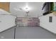 Spacious garage featuring a white door with R-Tech insulation, a ceiling light, and a painted floor at 6707 Greendale Ln, Indianapolis, IN 46241