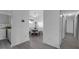Hallway view to kitchen and dining area with wood-look floors, and white walls and trim, and closet doors at 6707 Greendale Ln, Indianapolis, IN 46241