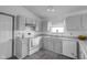Well-lit kitchen with white appliances, laminate countertops, and ample cabinet space with an adjacent door at 6707 Greendale Ln, Indianapolis, IN 46241