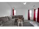 Bright living room featuring hardwood floors, a gray sectional sofa, and large windows with curtains at 6707 Greendale Ln, Indianapolis, IN 46241