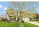 Charming two-story home featuring gray siding, a brick accent, a well-manicured lawn, and an attached two-car garage at 695 Bobtail Dr, Greenfield, IN 46140