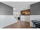 Hallway featuring hardwood floors, white wainscoting, gray walls, and an open view into the adjacent kitchen at 695 Bobtail Dr, Greenfield, IN 46140
