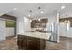 Modern kitchen featuring an island with a sink, stainless steel appliances, and dark wood cabinetry at 695 Bobtail Dr, Greenfield, IN 46140