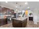 Modern kitchen featuring an island with a sink, stainless steel appliances, dark wood cabinetry, and granite countertops at 695 Bobtail Dr, Greenfield, IN 46140