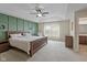 Main bedroom with paneled accent wall, decorative ceiling fan, and private bathroom at 695 Bobtail Dr, Greenfield, IN 46140