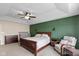 Bedroom boasts beautiful ceiling fan, hardwood furniture, chair, and accent wall at 695 Bobtail Dr, Greenfield, IN 46140