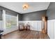 Bright home office with wood floors, white wainscoting, gray walls, and a large window for natural light at 695 Bobtail Dr, Greenfield, IN 46140