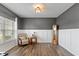 Bright home office with wood floors, white wainscoting, gray walls, and a large window for natural light at 695 Bobtail Dr, Greenfield, IN 46140