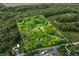 Aerial view showcasing the log home with boundary lines on a vast, wooded lot, offering privacy and a serene country setting at 6968 S 300 W, Trafalgar, IN 46181