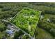 Expansive aerial view of property with wooded acreage outlined in white, offering privacy and seclusion at 6968 S 300 W, Trafalgar, IN 46181