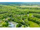 Wide aerial shot featuring the property surrounded by dense woodlands and neighboring residences at 6968 S 300 W, Trafalgar, IN 46181