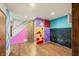 Colorful finished basement with stairs and access to unfinished area with wood-look flooring at 6968 S 300 W, Trafalgar, IN 46181
