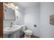 Powder blue half bath with pedestal sink, toilet, and a framed mirror above the sink at 6968 S 300 W, Trafalgar, IN 46181