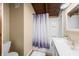 Bathroom featuring shower with purple patterned curtain, white sink, and a beige wall at 6968 S 300 W, Trafalgar, IN 46181