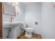 Cozy half bathroom featuring a pedestal sink, toilet, and traditional lighting fixture at 6968 S 300 W, Trafalgar, IN 46181