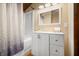 Bathroom featuring shower with patterned curtain, white vanity, and decorative details at 6968 S 300 W, Trafalgar, IN 46181