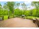 Wooden deck overlooking lush greenery, featuring built-in benches and a grill, ideal for outdoor relaxation and entertaining at 6968 S 300 W, Trafalgar, IN 46181