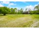 Charming log cabin nestled in a lush, green landscape with gravel driveway and bright blue sky at 6968 S 300 W, Trafalgar, IN 46181