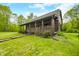 Quaint log cabin home with a covered front porch and stone walkway amidst a lush green lawn and mature trees at 6968 S 300 W, Trafalgar, IN 46181