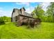 Inviting log cabin with a spacious deck and stairs, nestled in a lush green yard with mature trees, ideal for outdoor living at 6968 S 300 W, Trafalgar, IN 46181