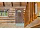 Inviting log cabin entrance featuring a charming wood door, window, and rustic wooden accents at 6968 S 300 W, Trafalgar, IN 46181