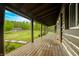 Inviting log cabin porch with wooden floors and picturesque views of the surrounding landscape at 6968 S 300 W, Trafalgar, IN 46181
