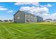 Expansive backyard with lush lawn and modern home exterior under a blue sky at 7132 Sterling Way, Brownsburg, IN 46112
