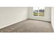 Bright bedroom with neutral carpet and a large window overlooking the yard at 7132 Sterling Way, Brownsburg, IN 46112
