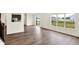 Bright open-concept living room features wood floors, a large window, and sliding glass doors to the backyard at 7132 Sterling Way, Brownsburg, IN 46112