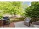 Relaxing back deck with grill and seating area surrounded by a lush backyard at 7606 Old Oakland Blvd E Dr, Indianapolis, IN 46236