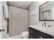Cozy bathroom featuring a shower with stylish curtain, dark vanity and framed mirror at 7606 Old Oakland Blvd E Dr, Indianapolis, IN 46236