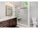Well-lit bathroom with an updated vanity, a mosaic mirror frame, and a walk-in glass shower at 7606 Old Oakland Blvd E Dr, Indianapolis, IN 46236